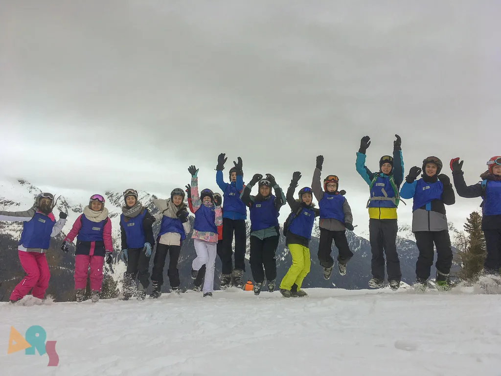 Gruppe jubelt mit erhobenen Armen auf der Kuppe.